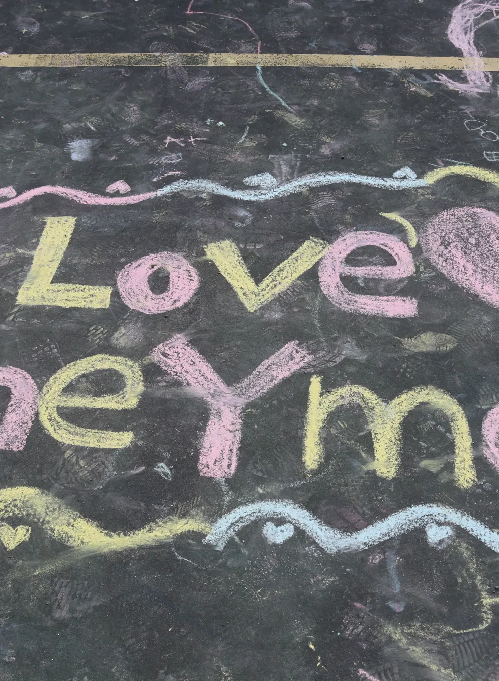 Sidewalk chalk art from a YMCA camper reading "I love the YMCA"