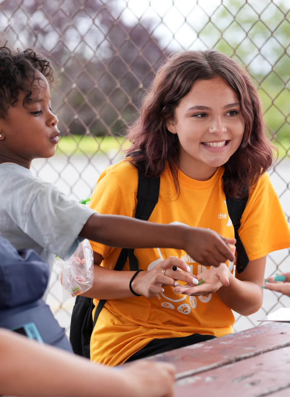Summer camp students smile at the table while playing a game at the YMCA