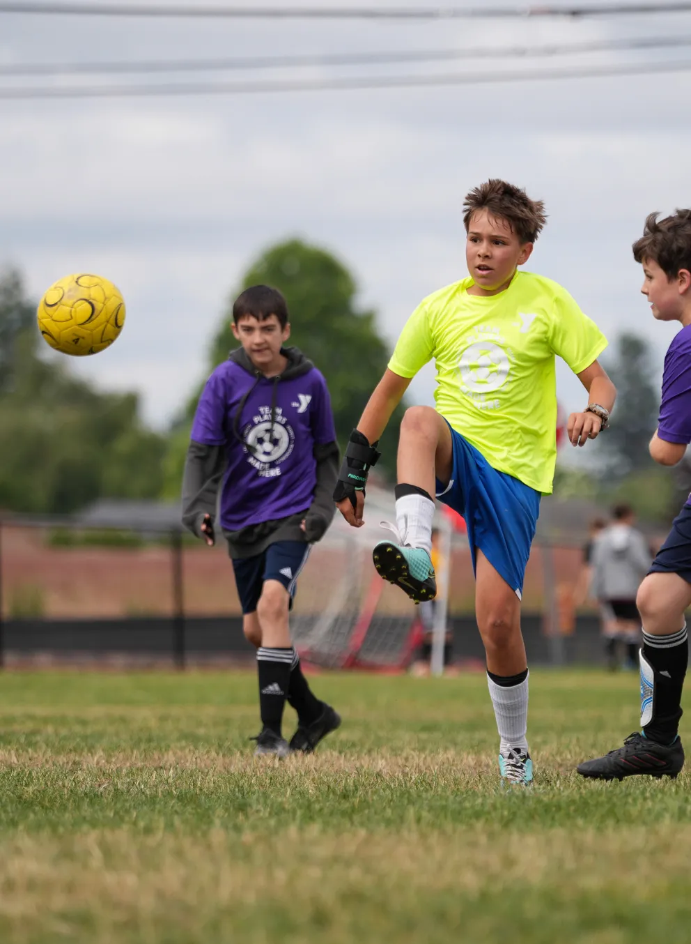 YMCA Youth Soccer League Kicking Ball into the Air