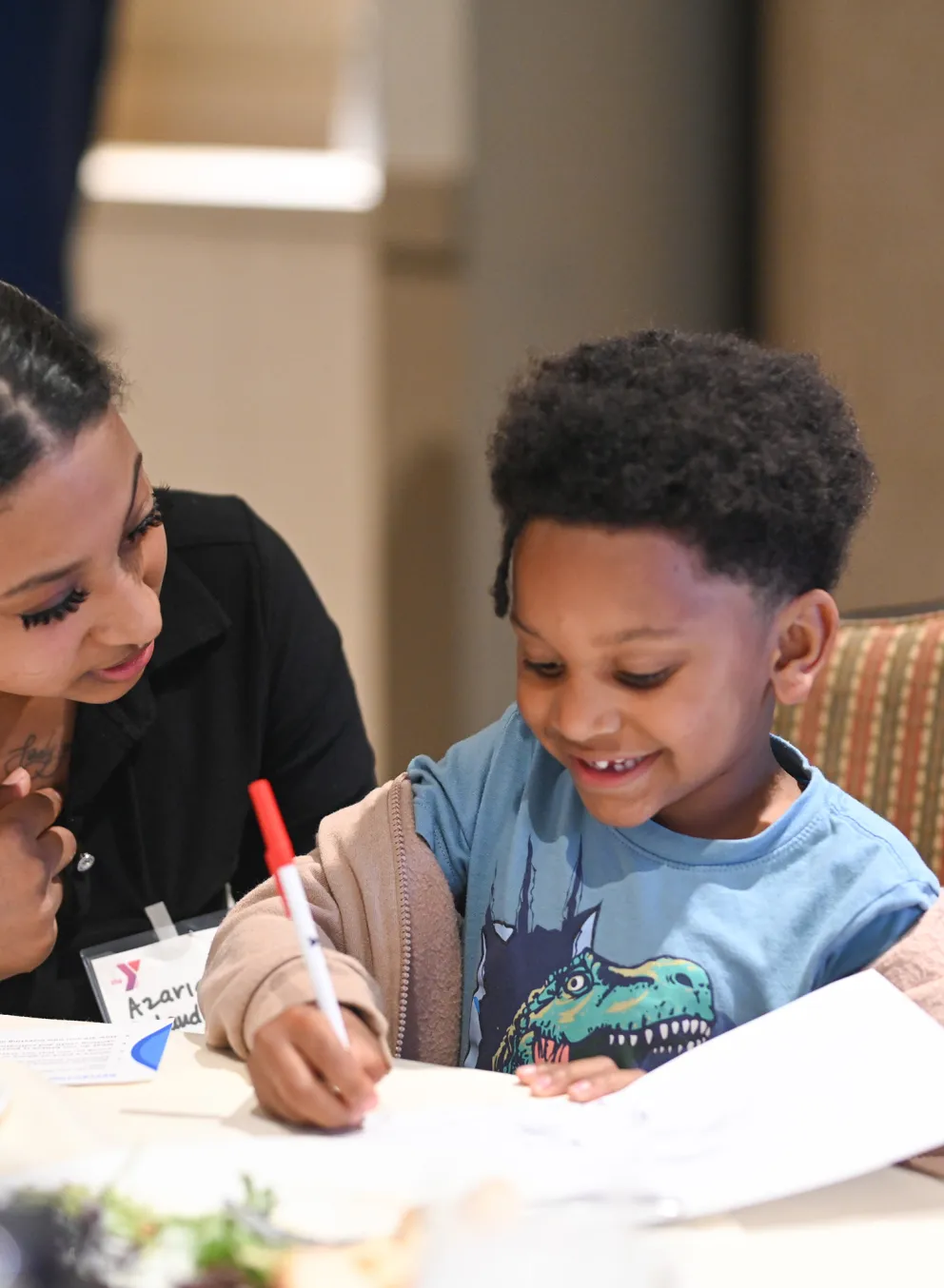 Staff Helping Young Student Draw