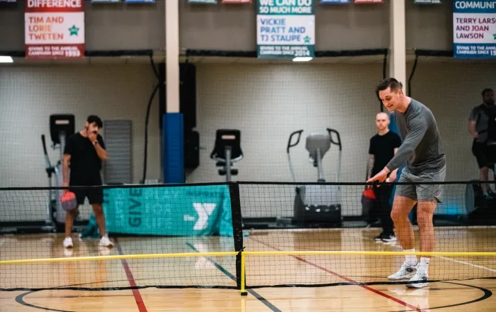 Pickleball player sets up to serve the ball at the YMCA