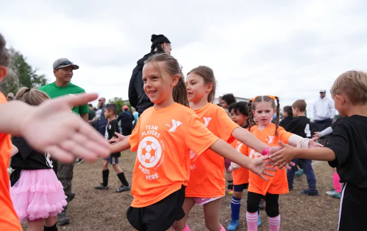 Action shot of a high five line at the end of a good soccer game at the YMCA