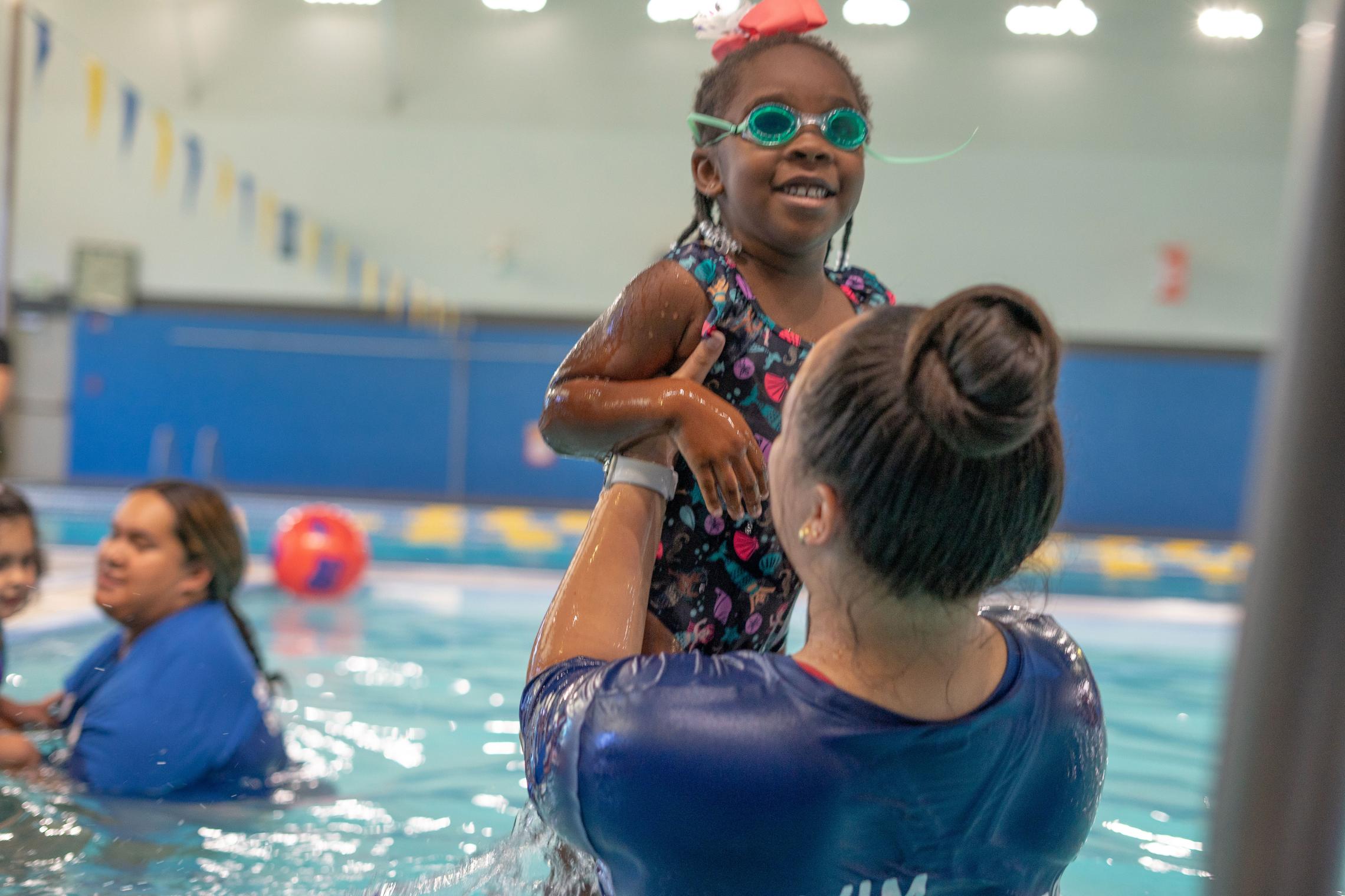 Lifting Up Swimmer At YMCA Swim Lessons