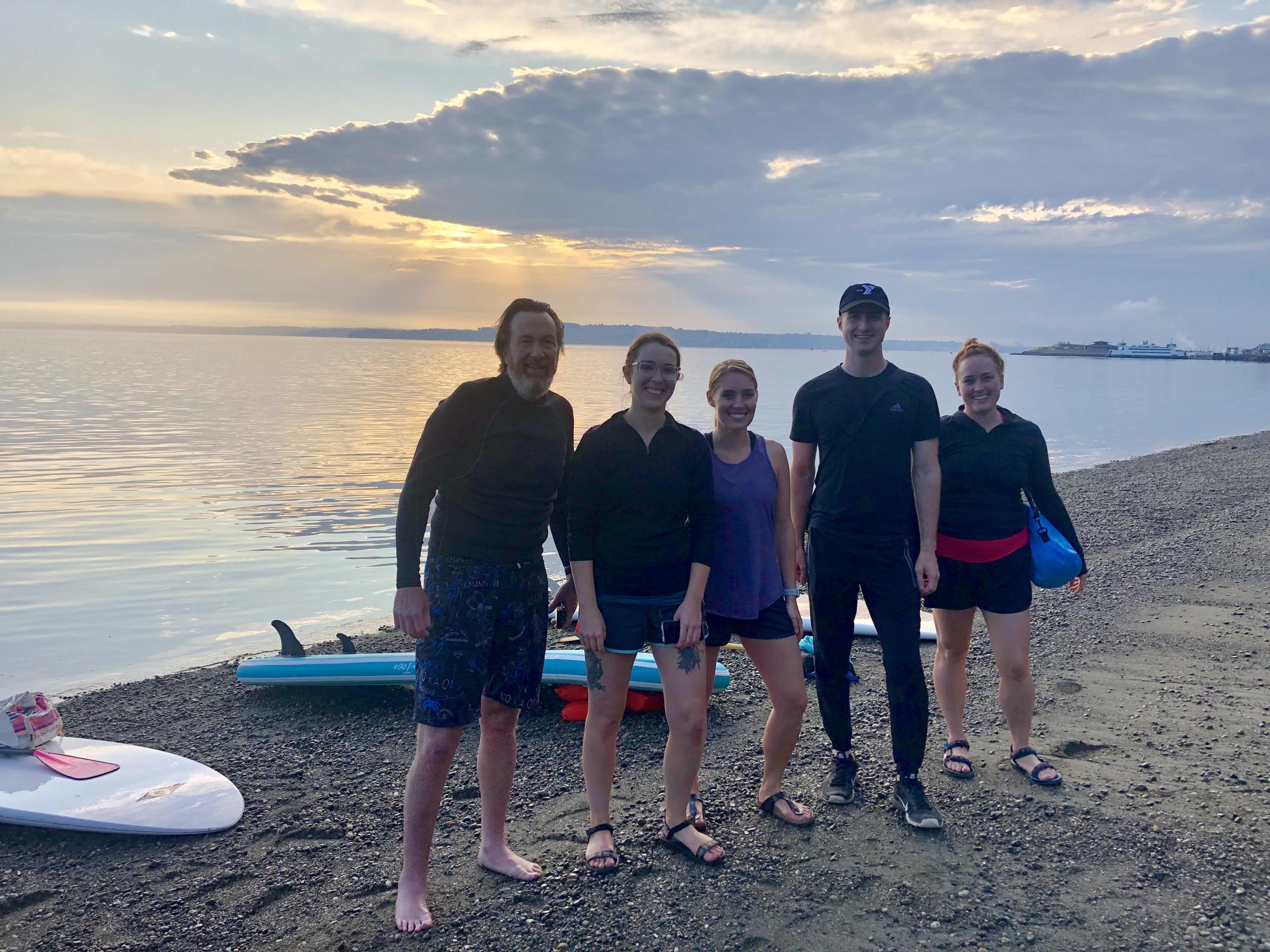 People stand in front of the water at Owen Beach at the Plunge