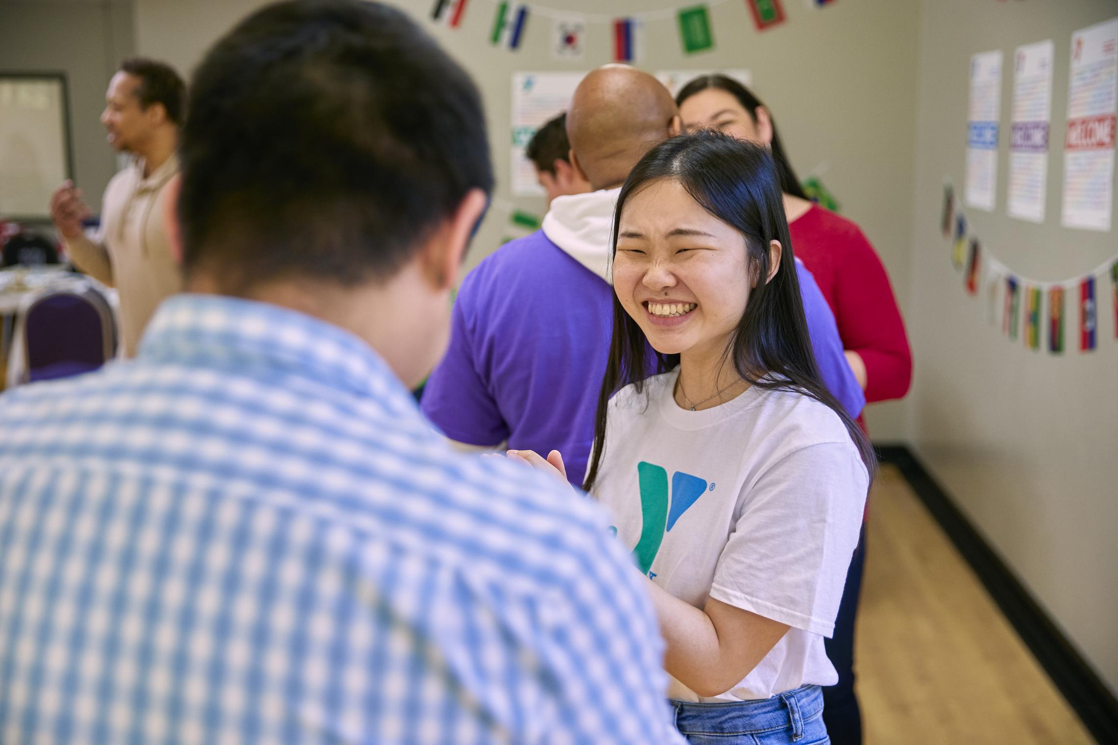 People gather in a YMCA Community Room in celebration of Welcoming Week 2022