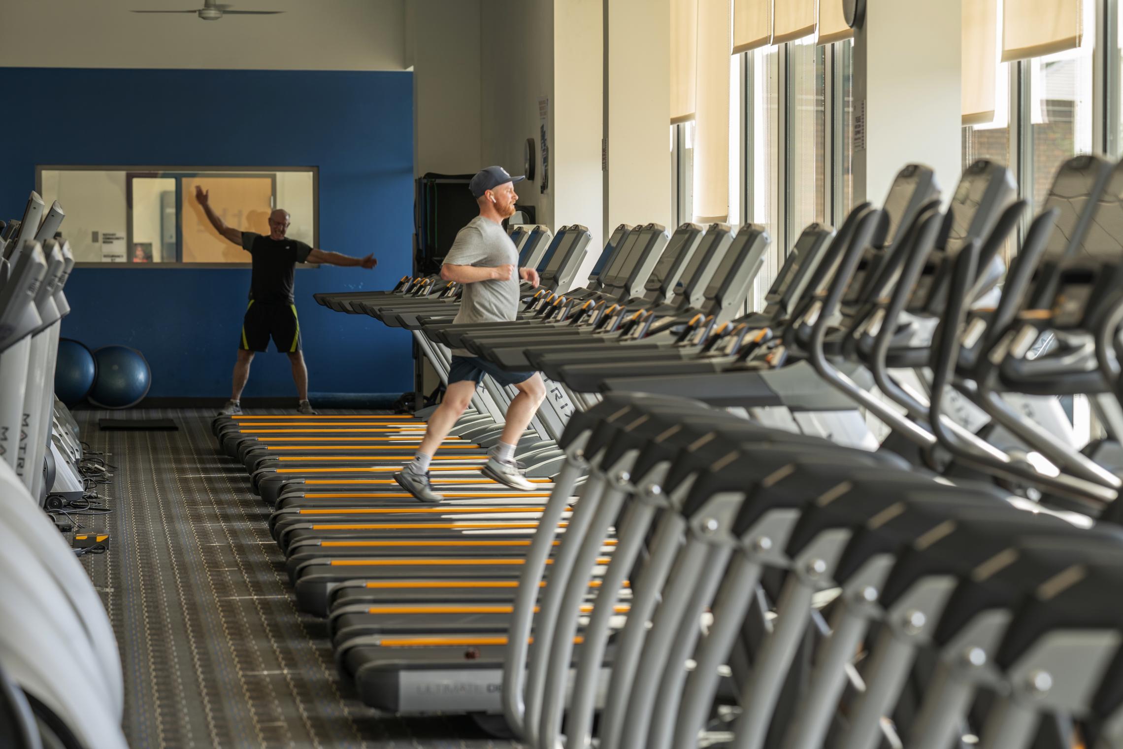 Two people work out at a YMCA community center.