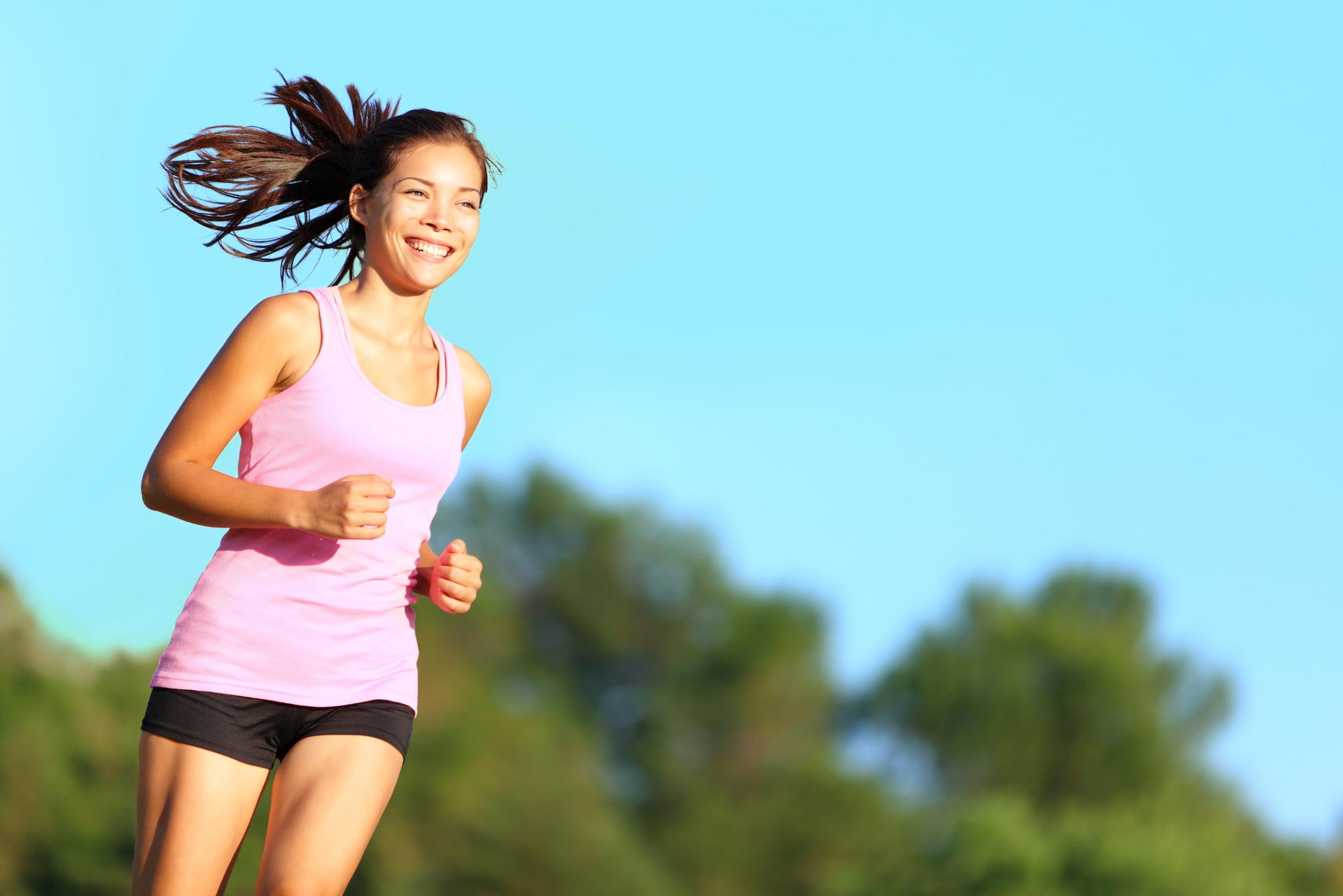 A person runs outdoors on a sunny day.