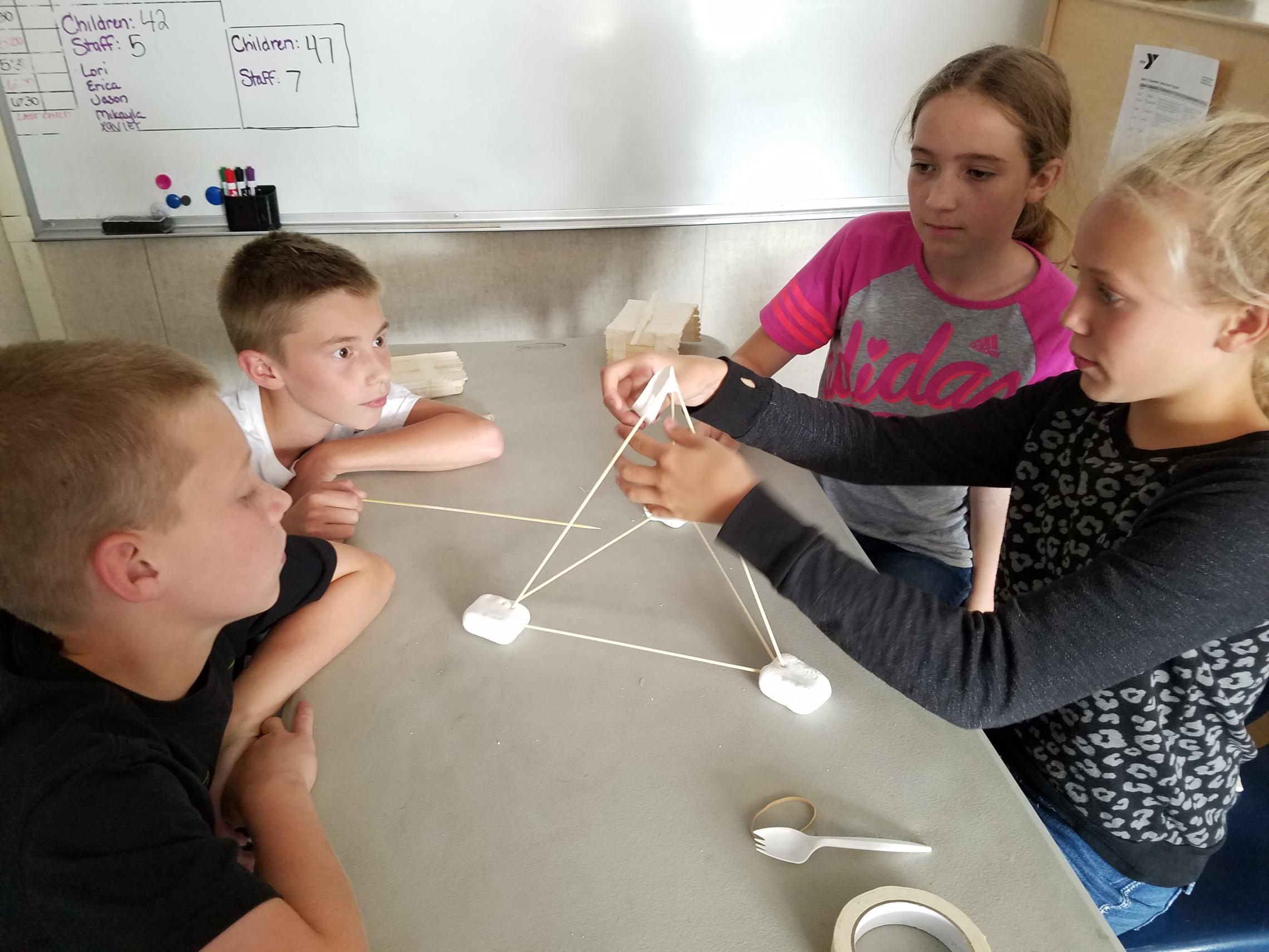 Camp youth constructing marshmallow pyramid