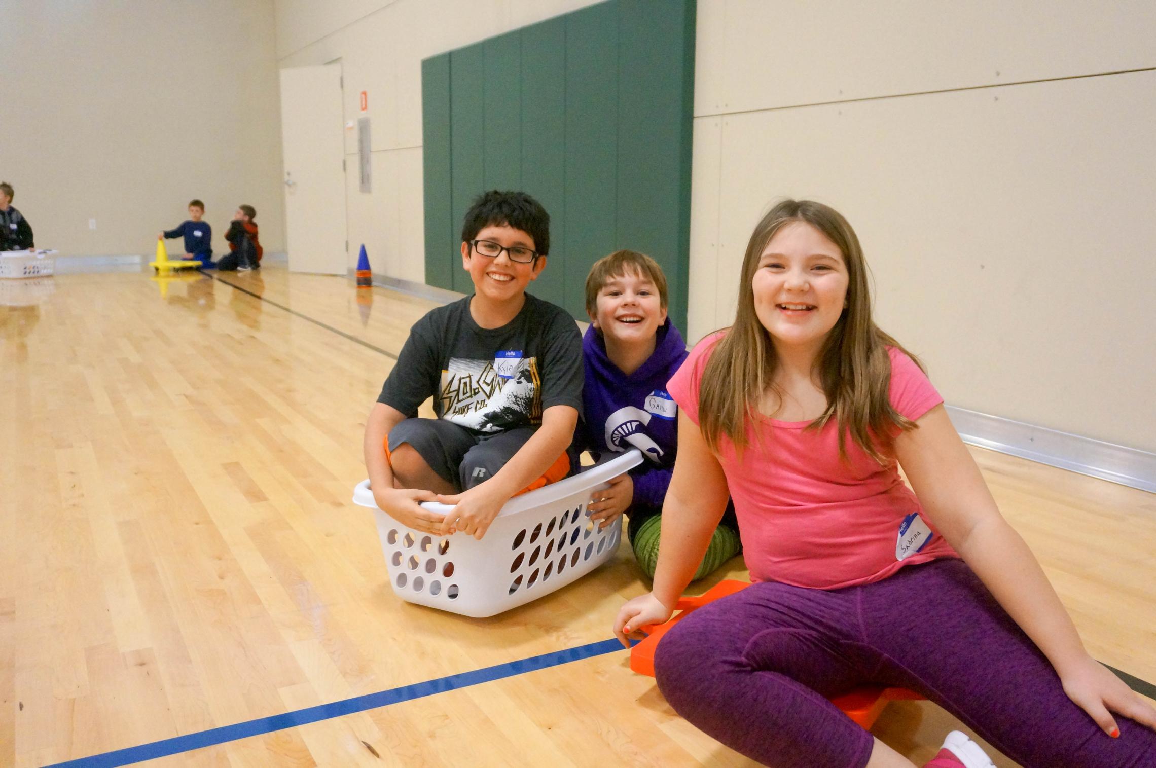 Camp participants playing gym game in a laundry basket