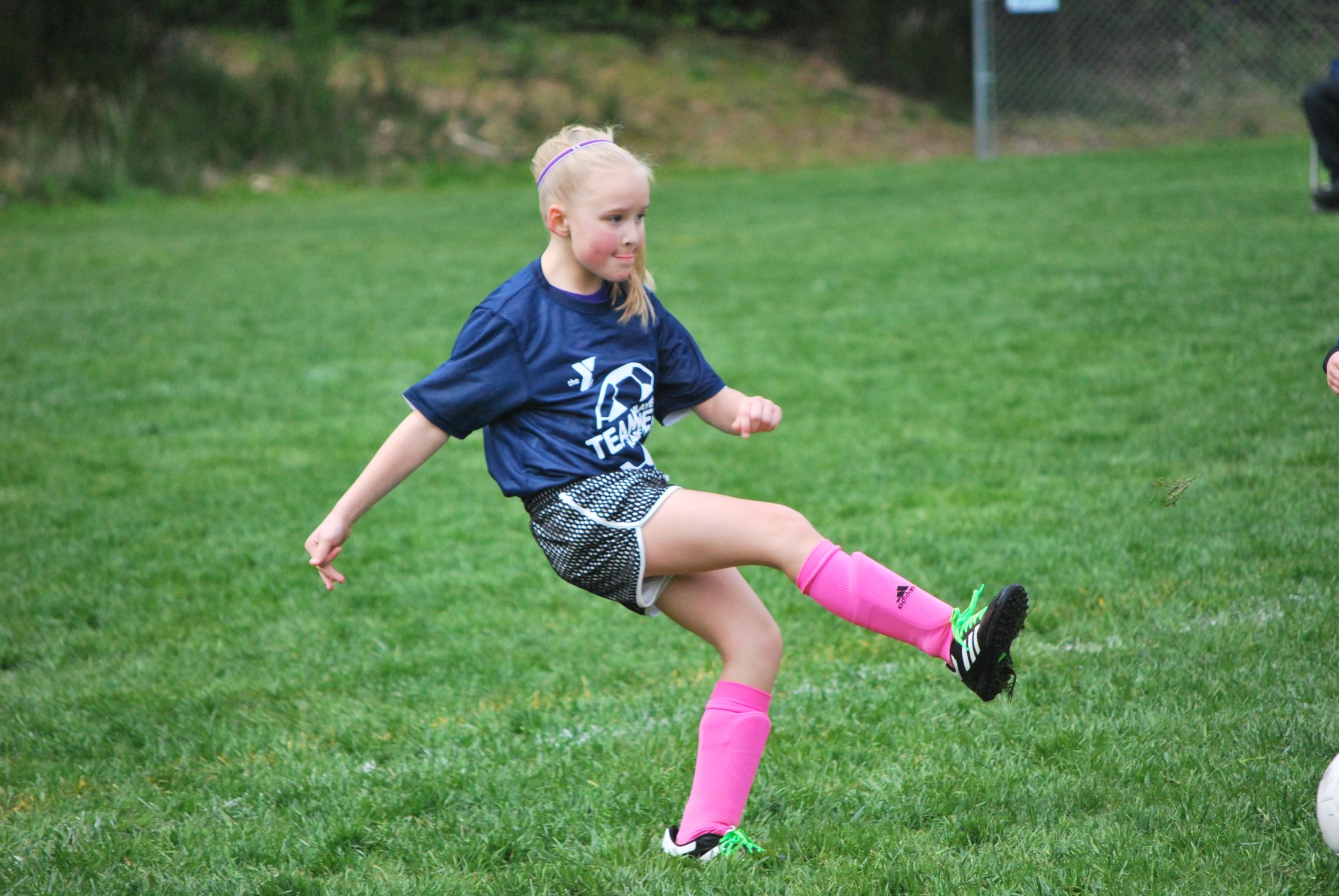 youth soccer player making a kick
