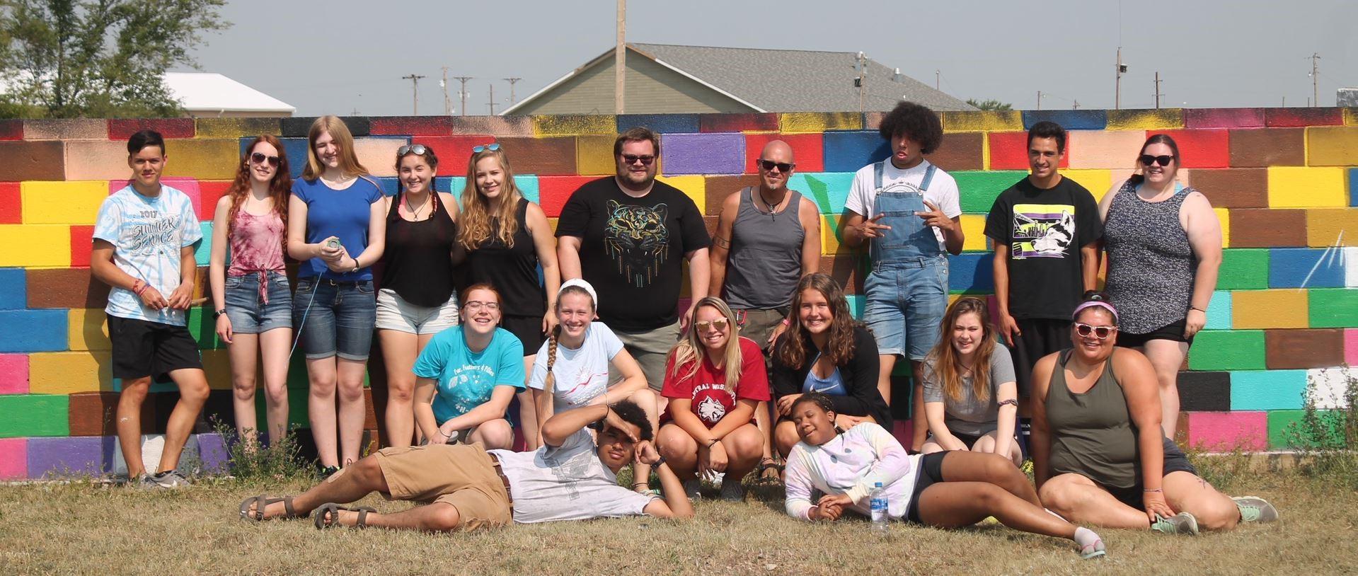 Future leaders, teens of the YMCA, pose against a vibrant wall mural. 
