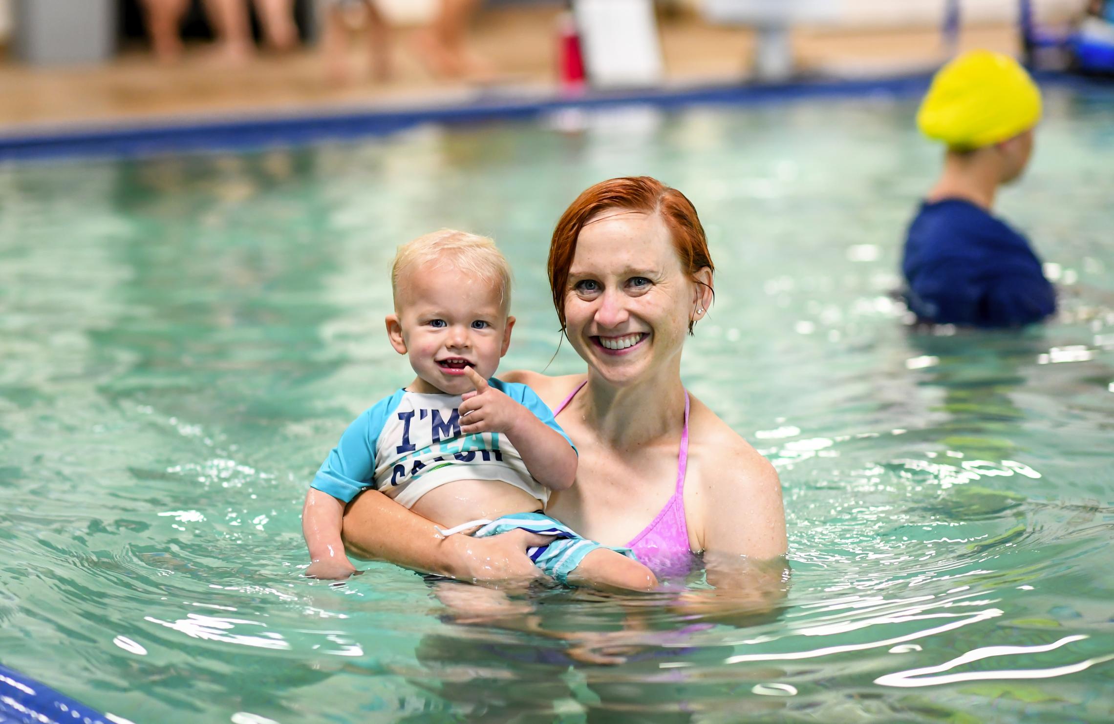 A parent and their toddler pose in the pool at Morgan Family YMCA