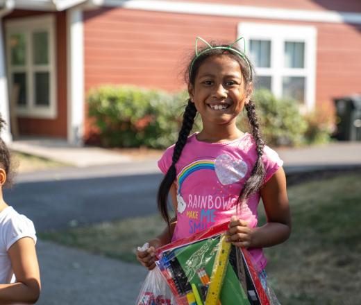 A child receives a package of school supplies from Y on the Fly.