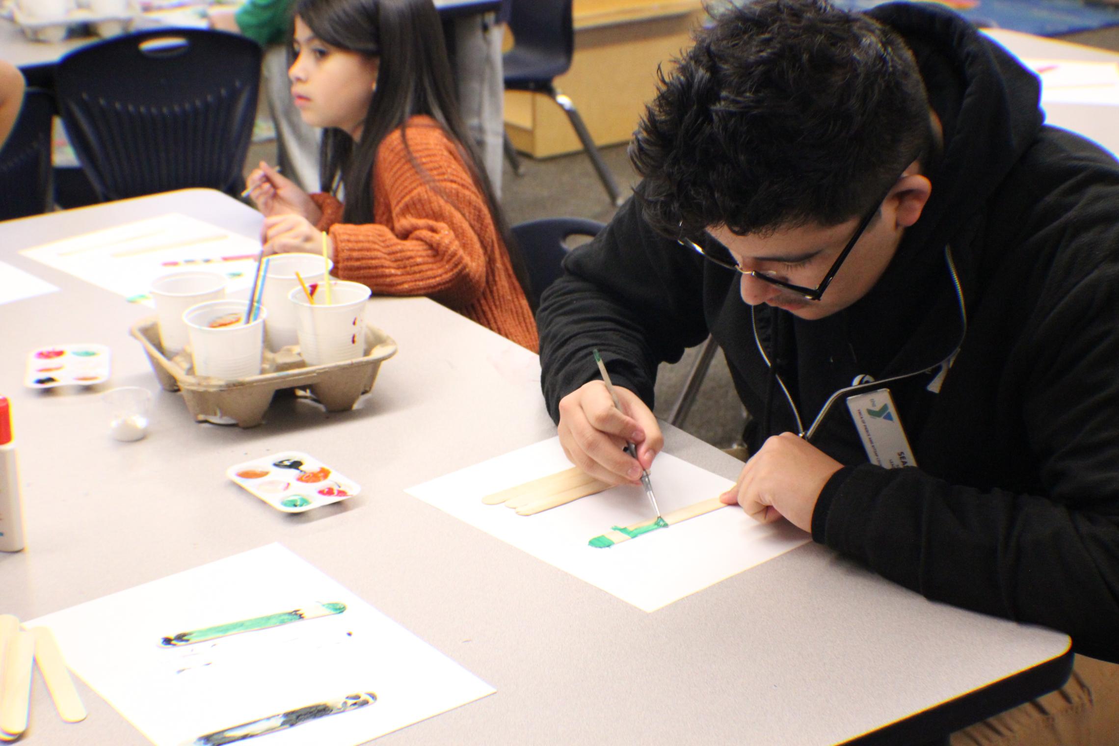 Site Leader Sean Chavez 18, working on an art project with the After School Care participants   