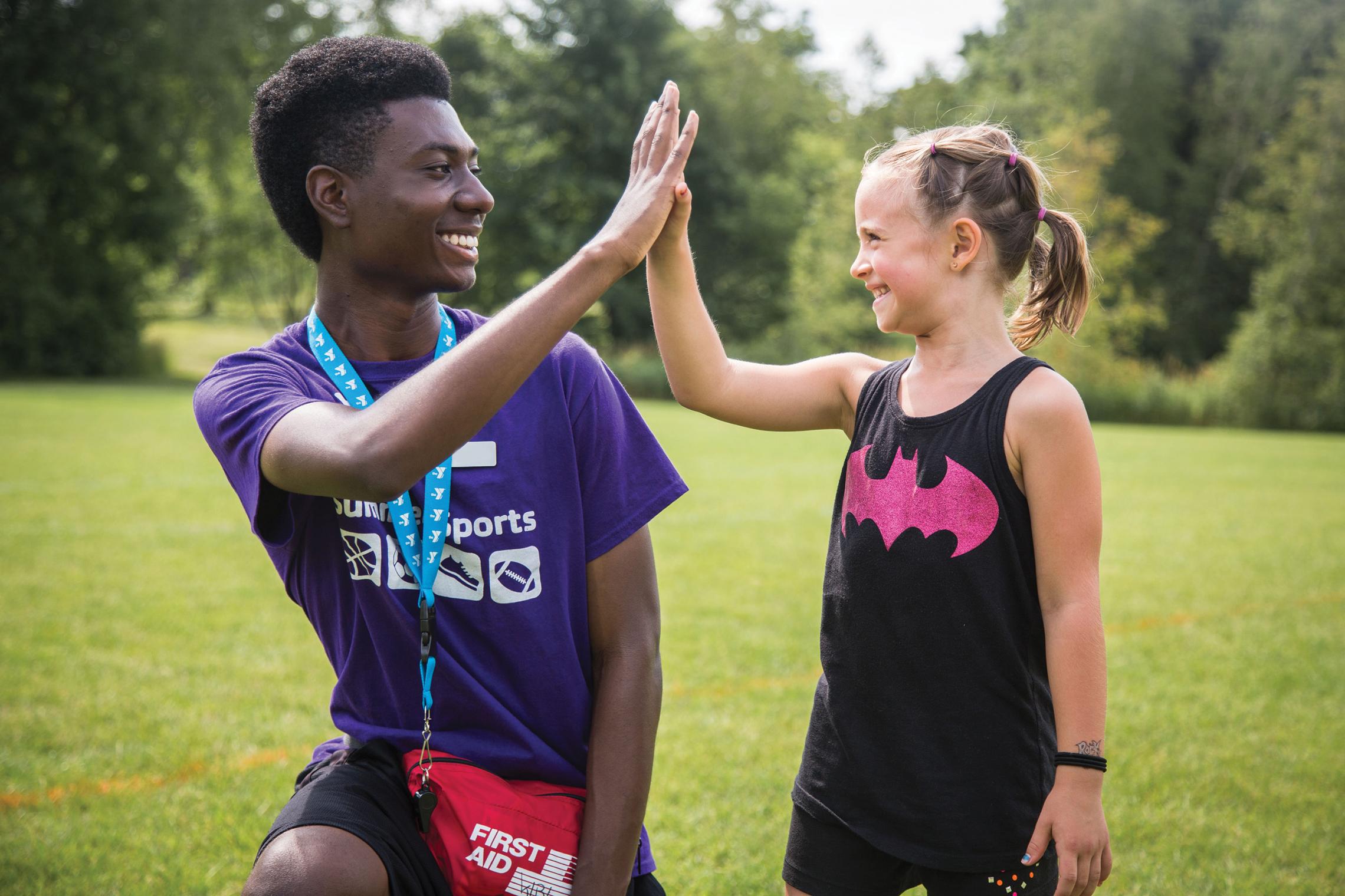 YMCA soccer coach high fives player