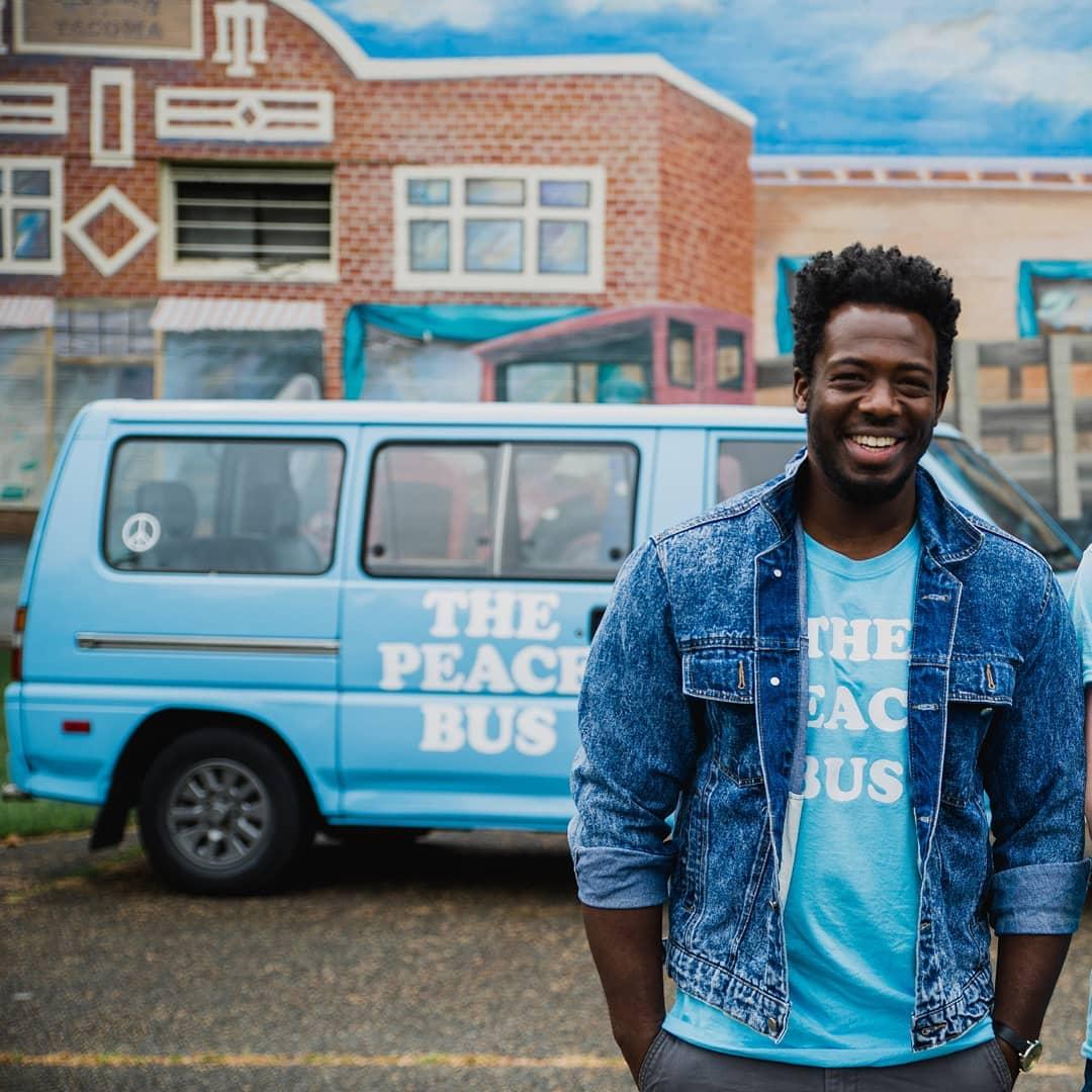 Kwabi stands in front of the Peace Bus in Tacoma, WA