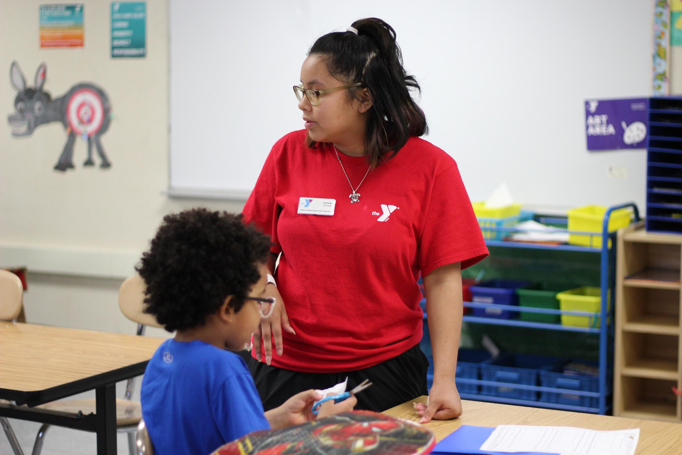 Irensia Topasna site lead at the Tillicum location helping a child with homework.