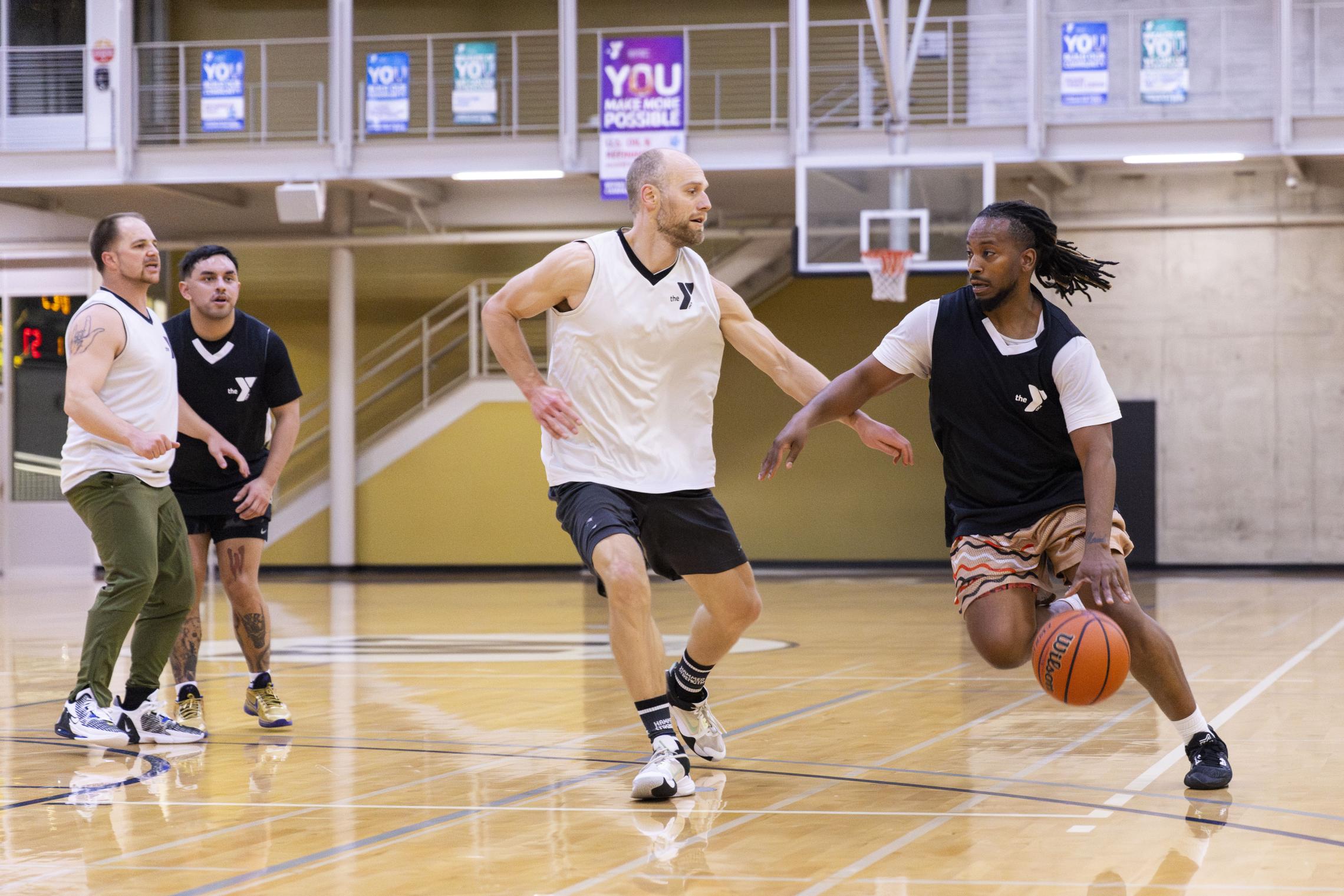 Action shot of a YMCA basketball player driving the ball to the key.