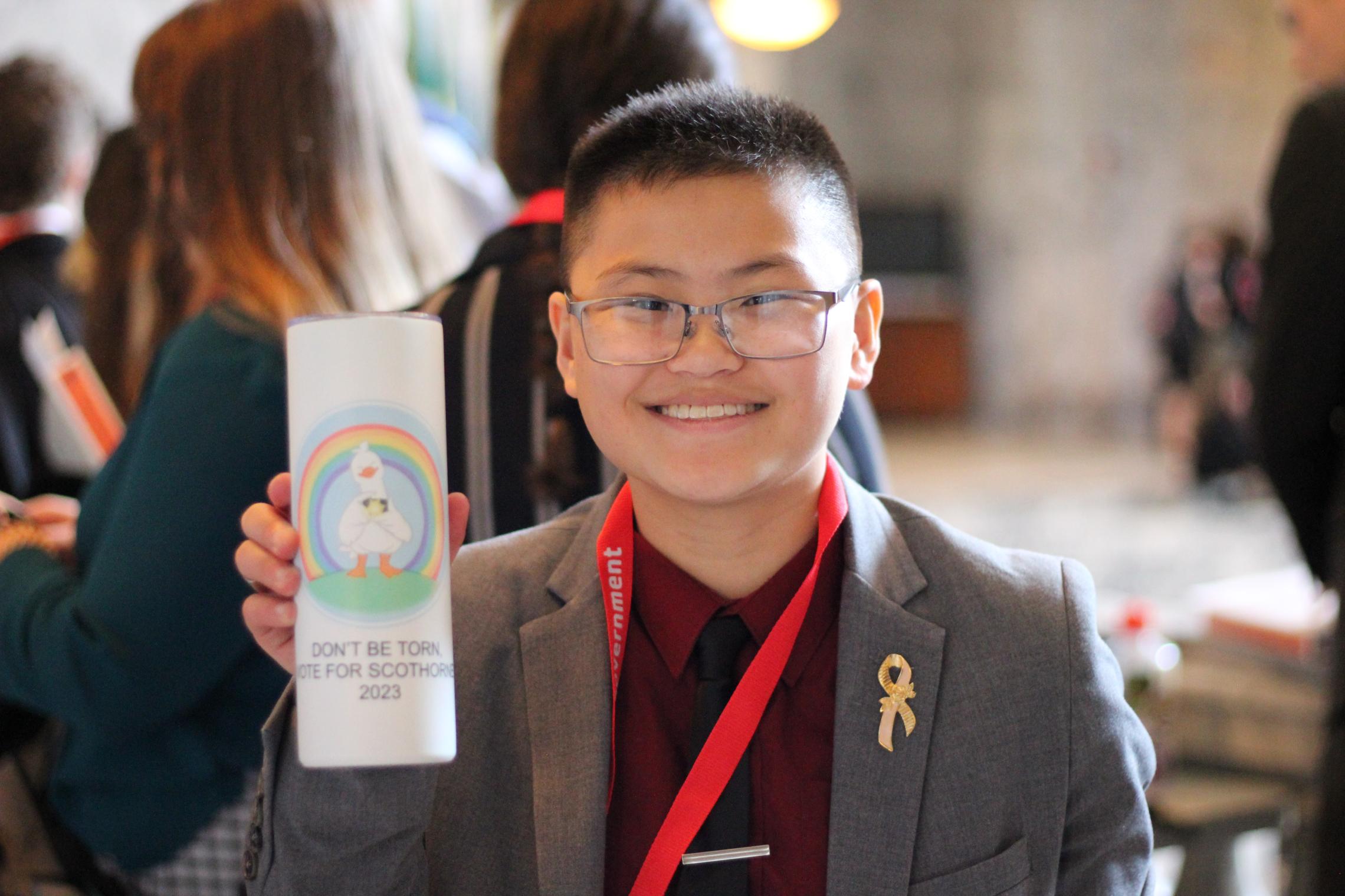 Youth and Government student holding up a pamphlet at an event at the YMCA