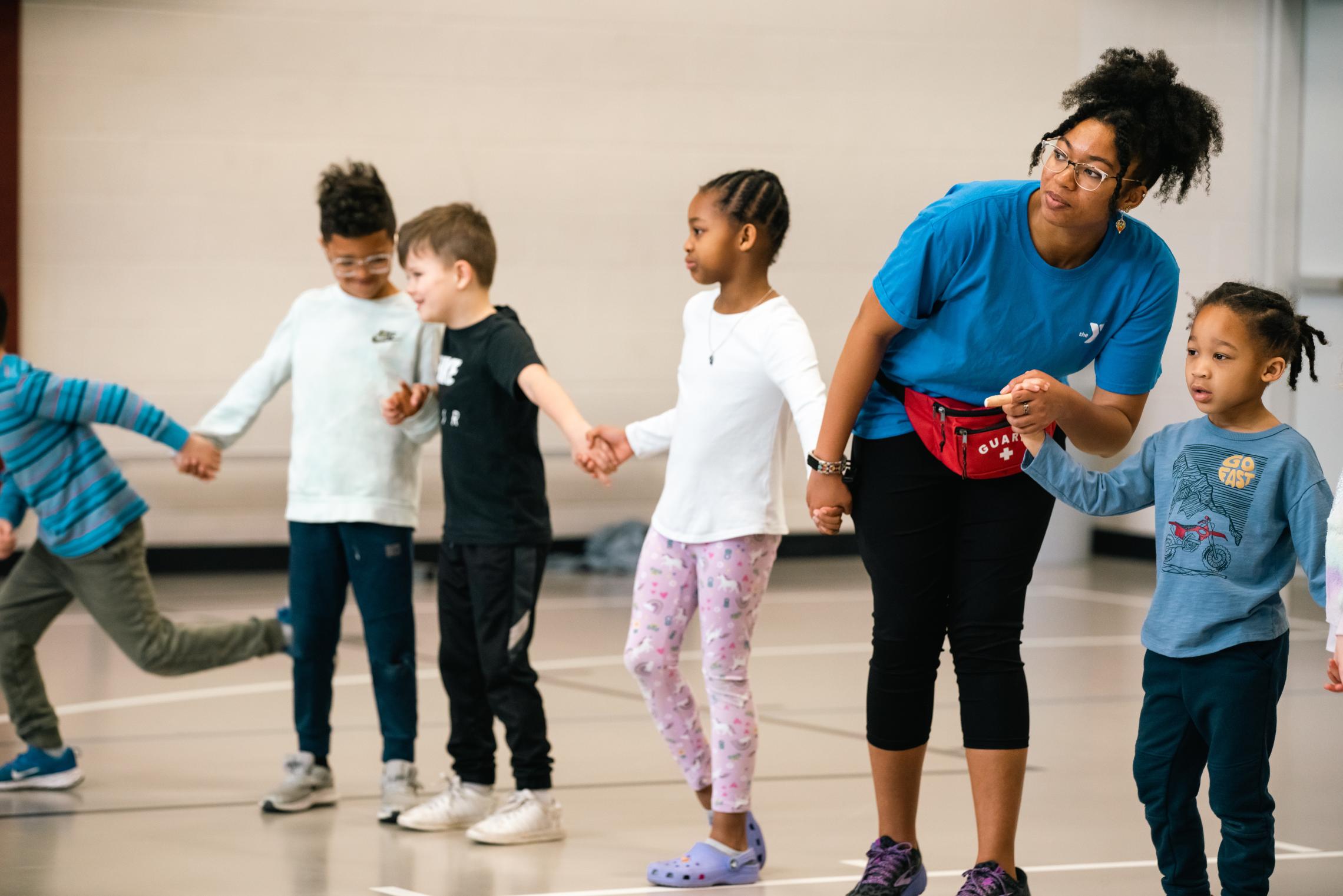 Healthy kids day participants join hands in an activity at the YMCA
