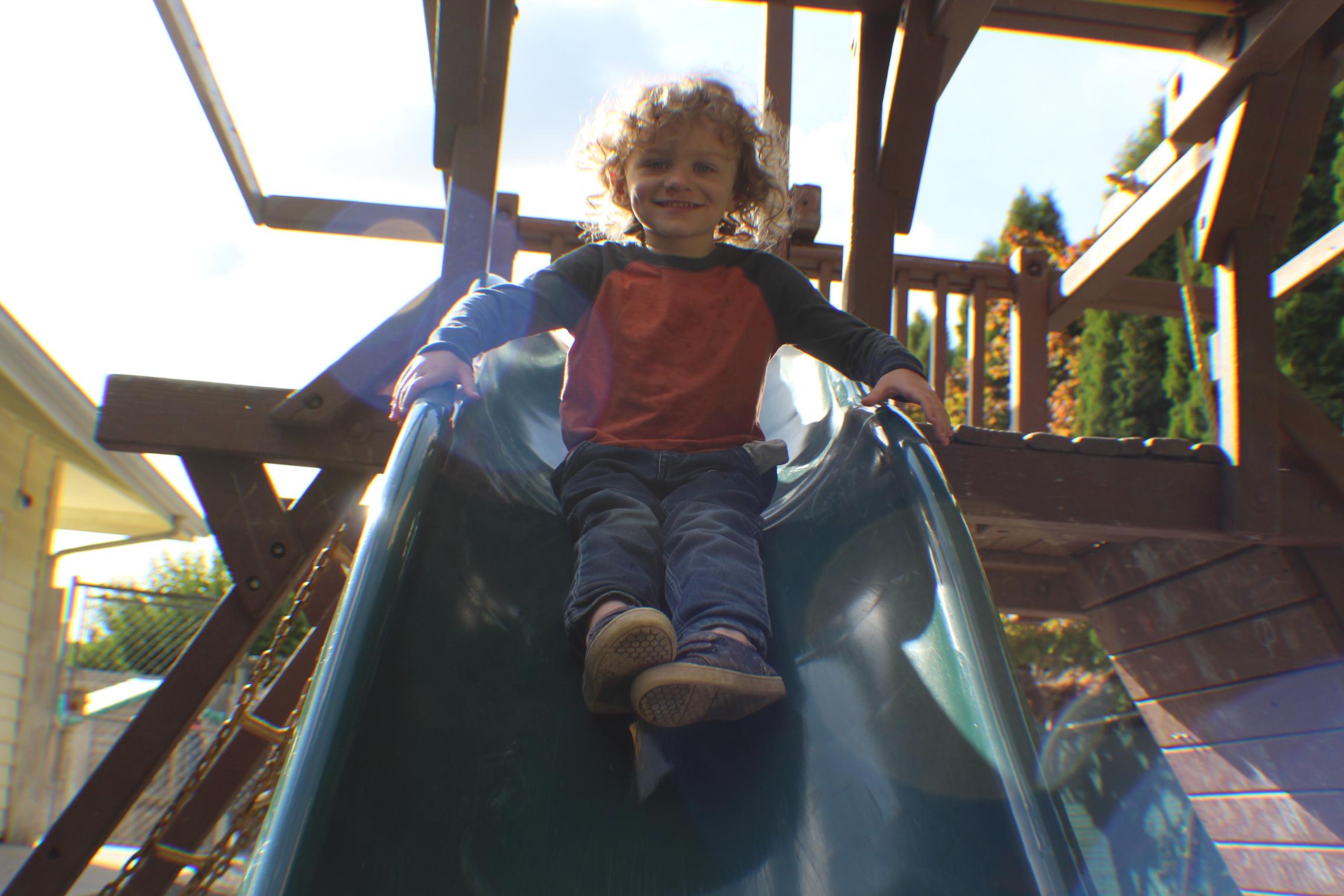 Child care participant goes down the slide at the YMCA