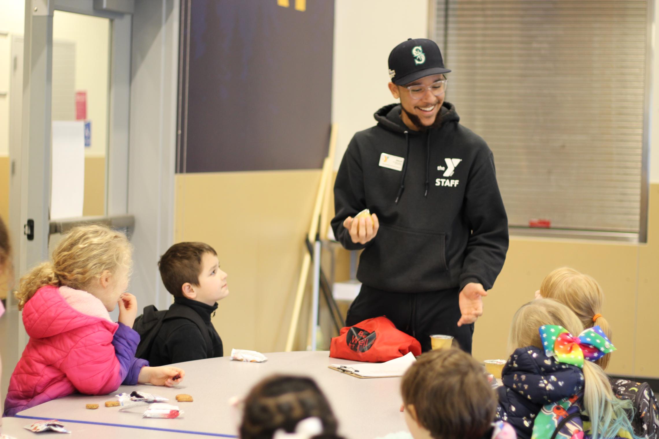 Child care staff leading a fun game during snack time at the YMCA