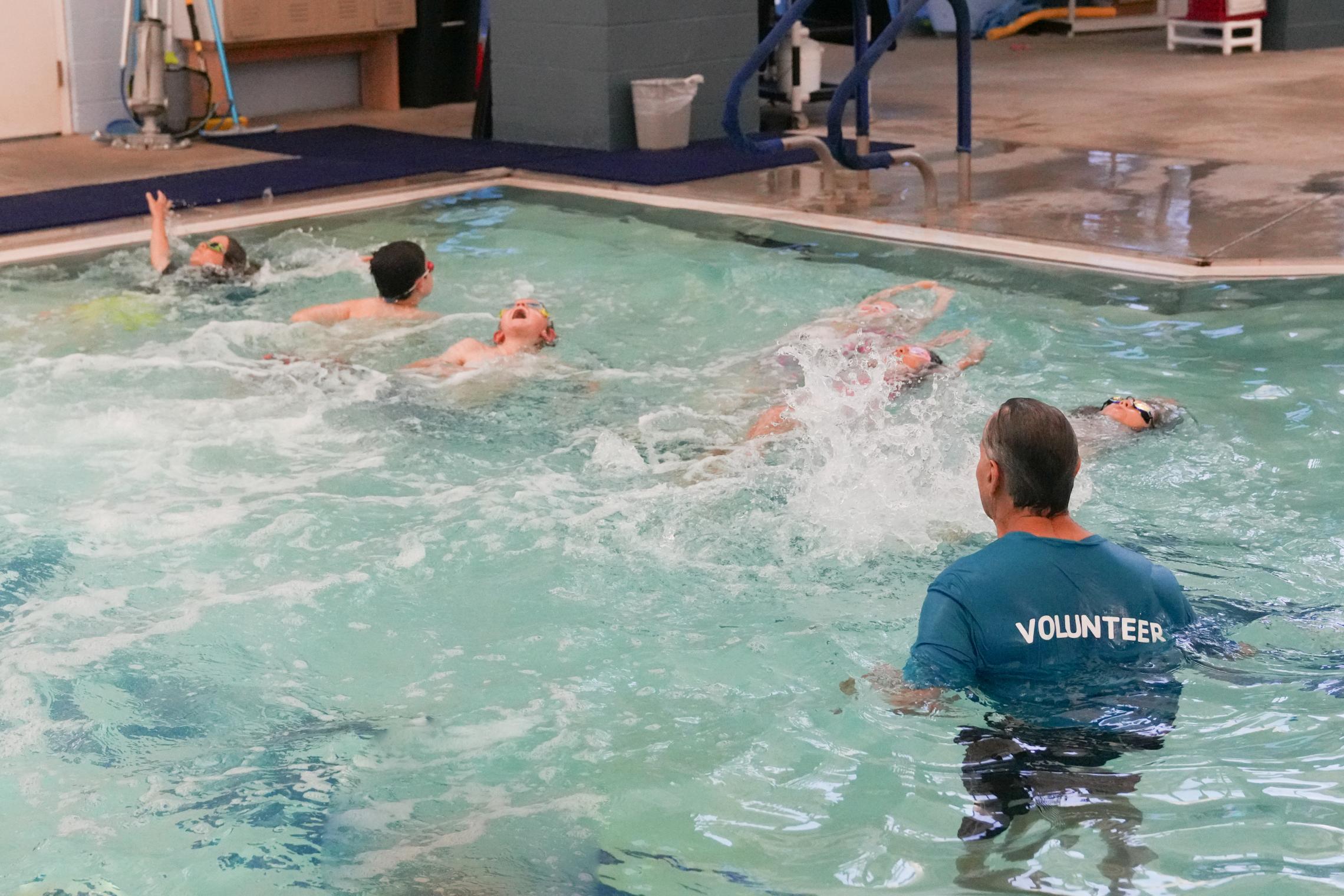 Children swim while Rick looks on