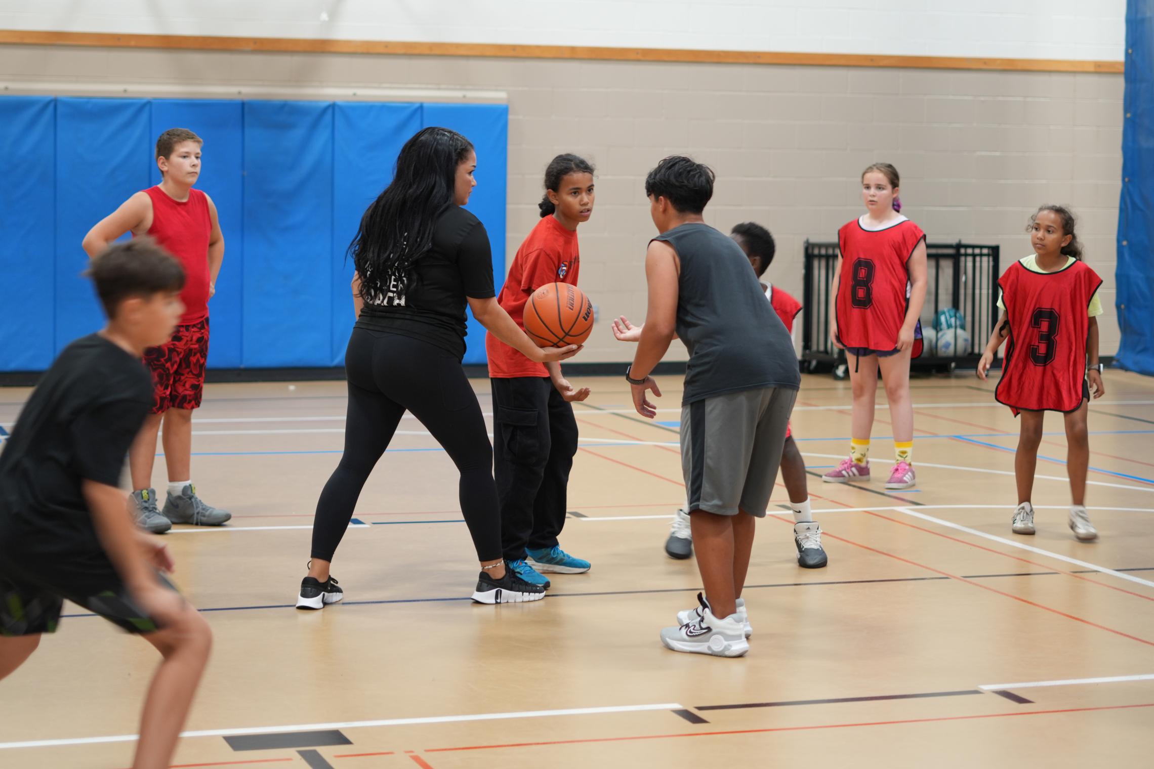 Coach Ali plays basketball with her team