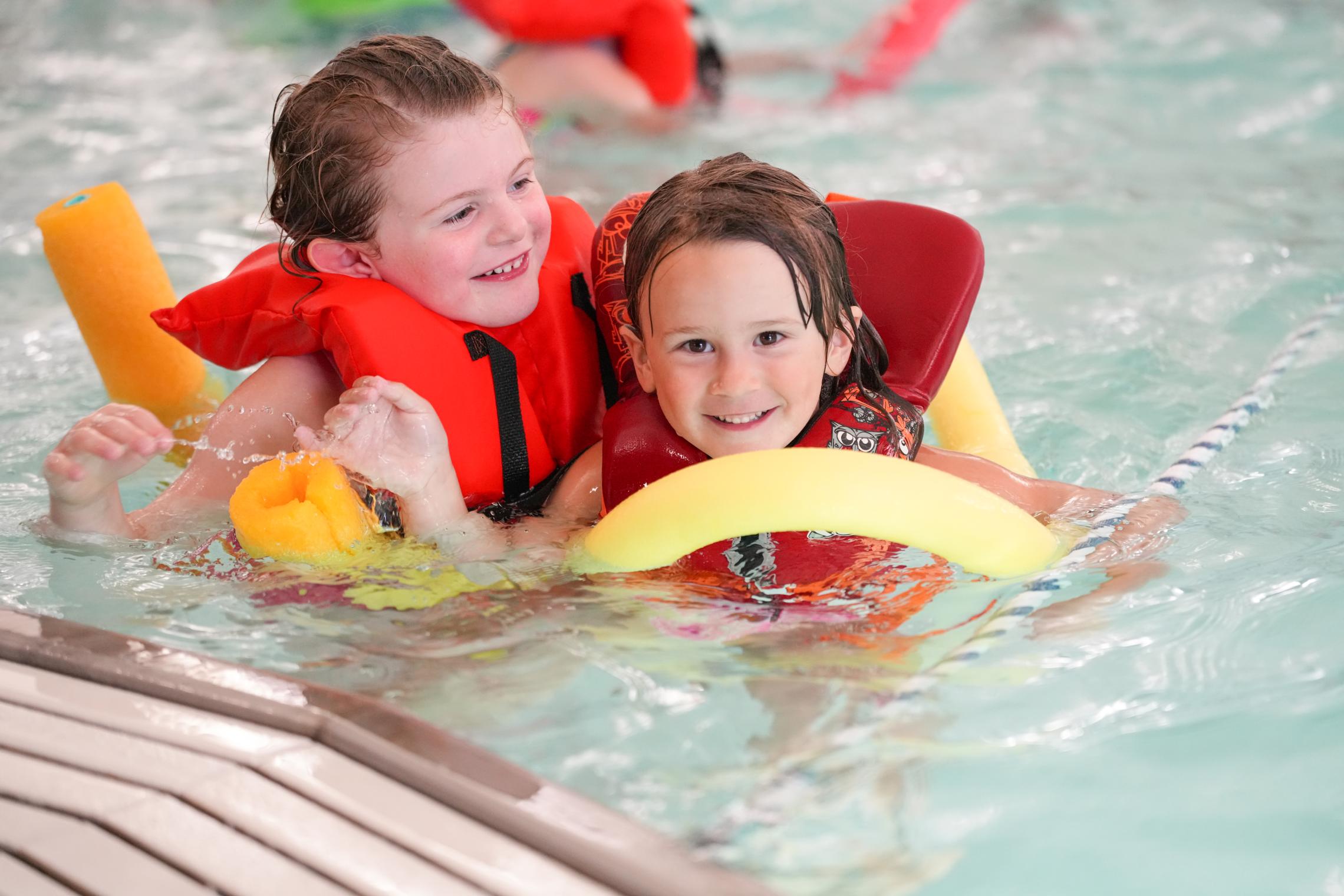 Two children play in the pool at the YMCA