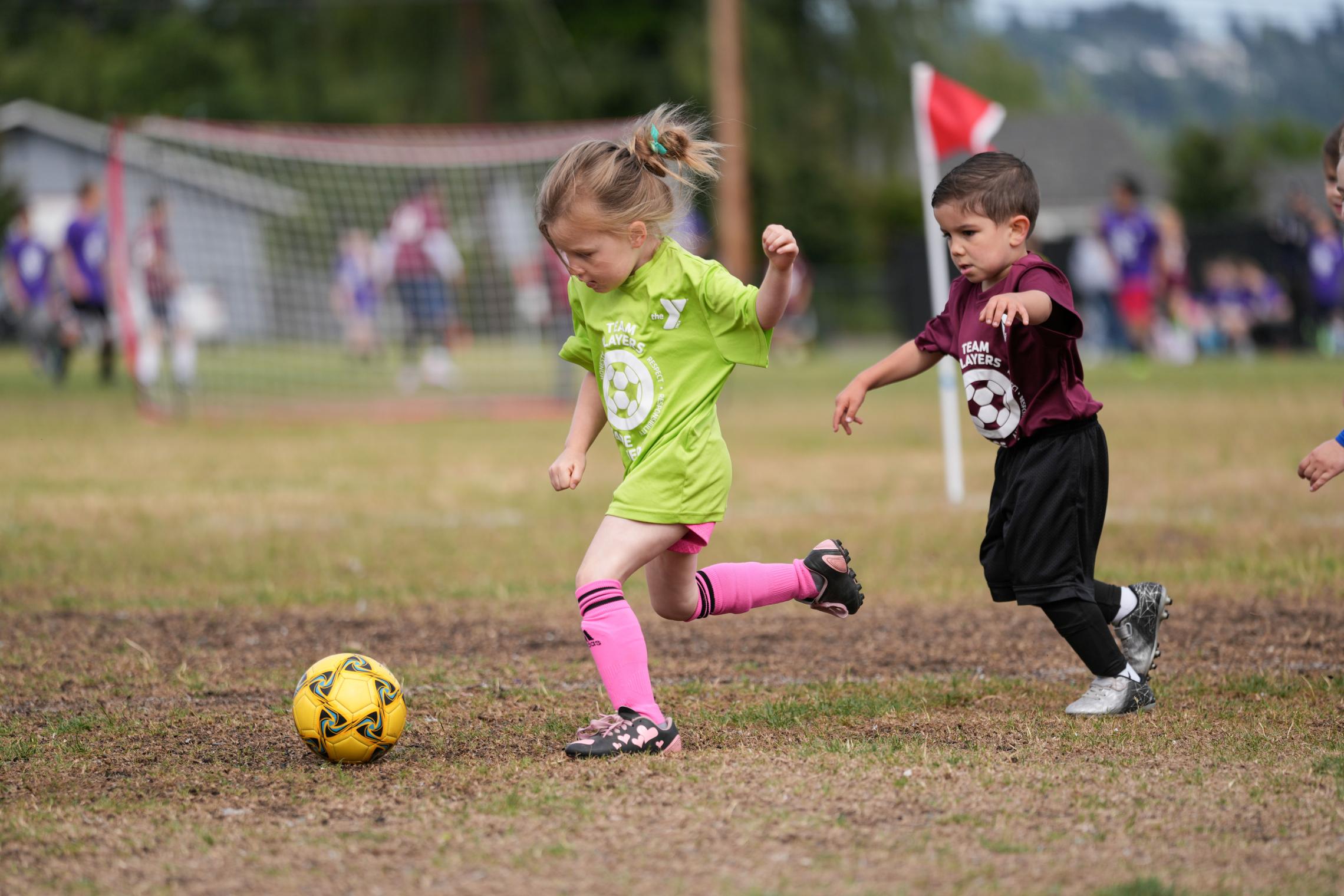 Children playing soccer during a youth sports game on a grassy field