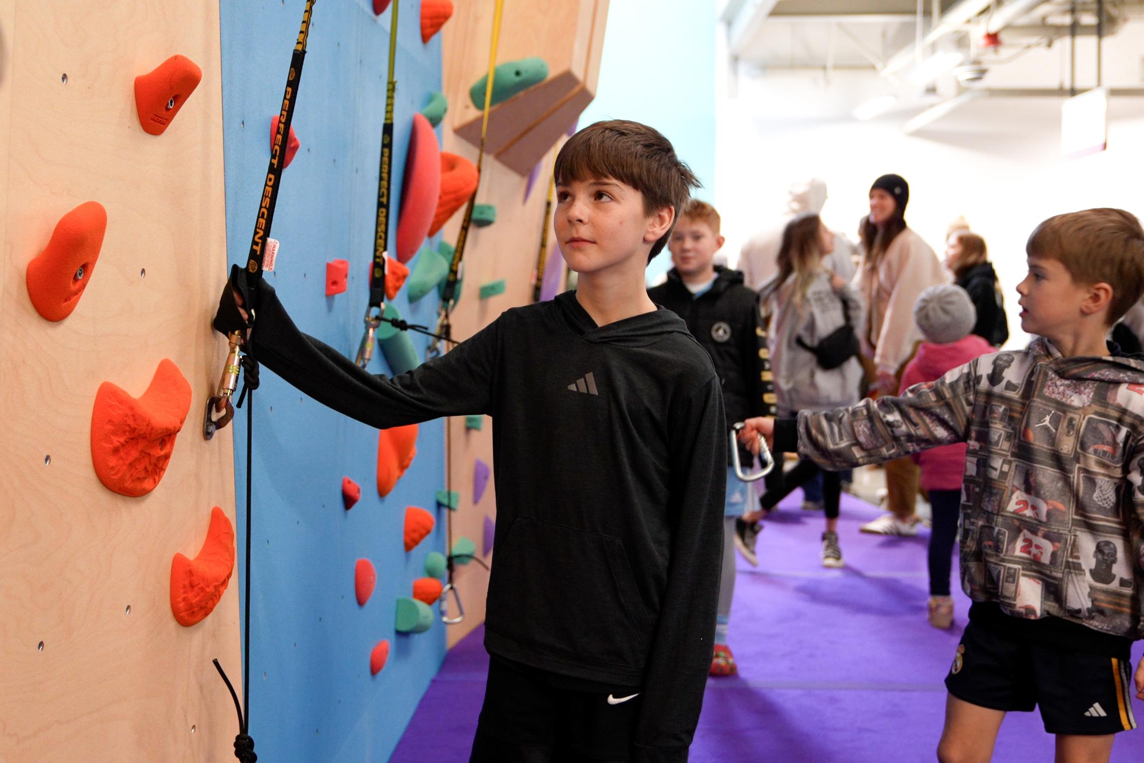 Children learn climbing safety and skills at the Liz Rocks Climbing Wall at the Pearl Street Family YMCA.