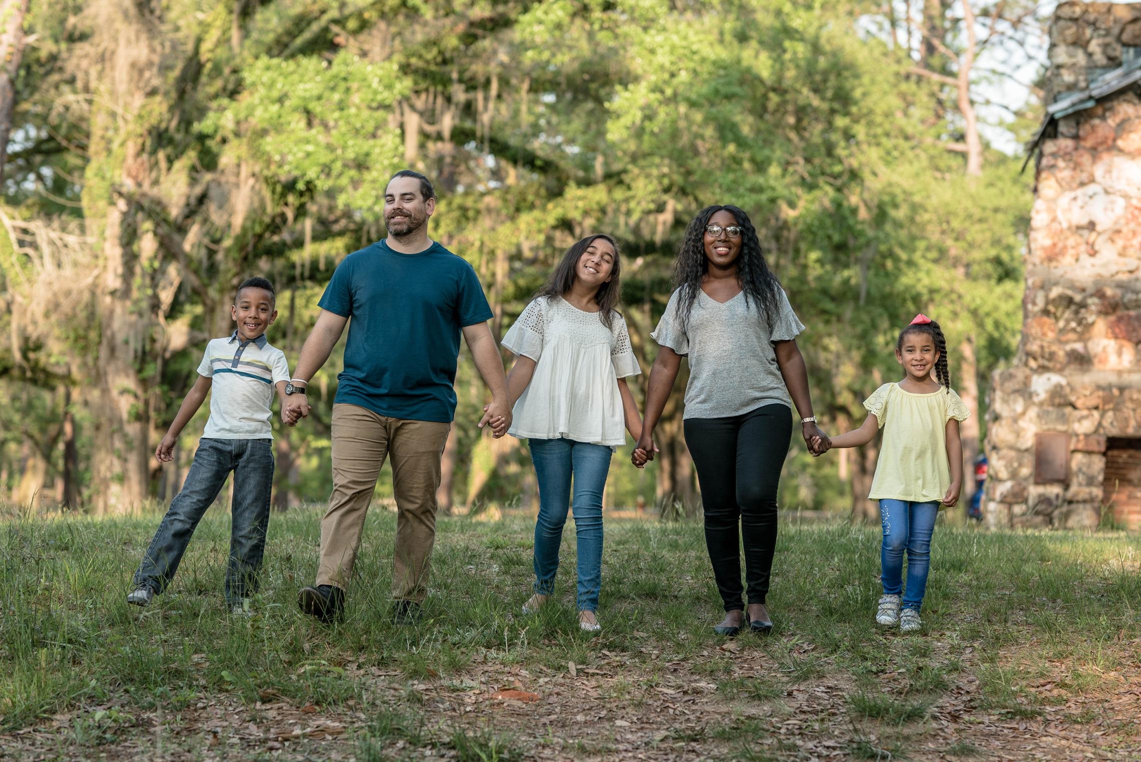 Family Holding Hands In The Park