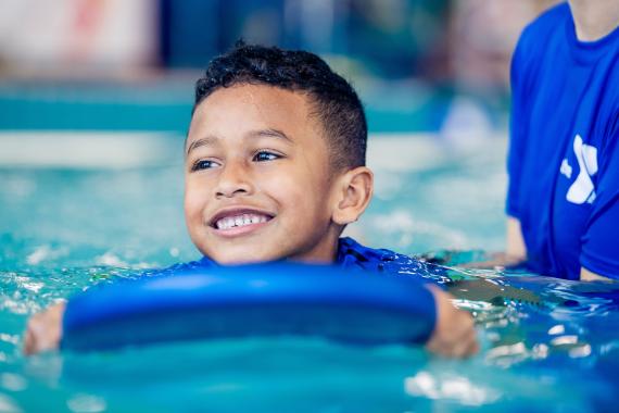 YMCA Youth Swim Lessons - Child On Paddle Board