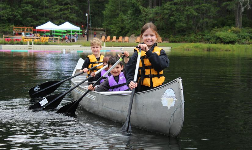 Four children canoeing at Camp Lake Helena