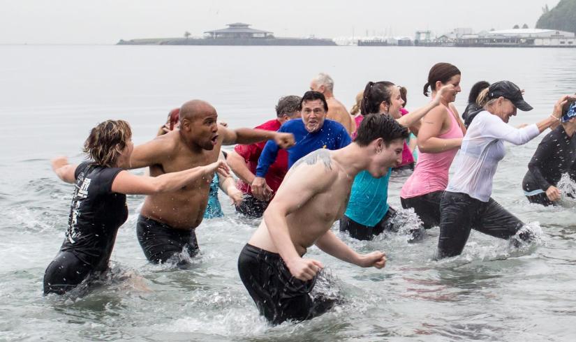 People run away from the cold Puget Sound at the Plunge event