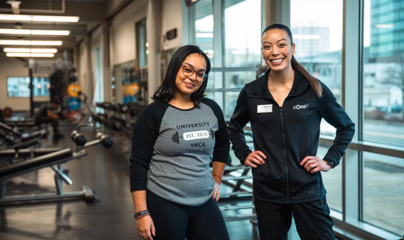 Wellness Coach Franchesca and a young woman member smile proudly at the camera.