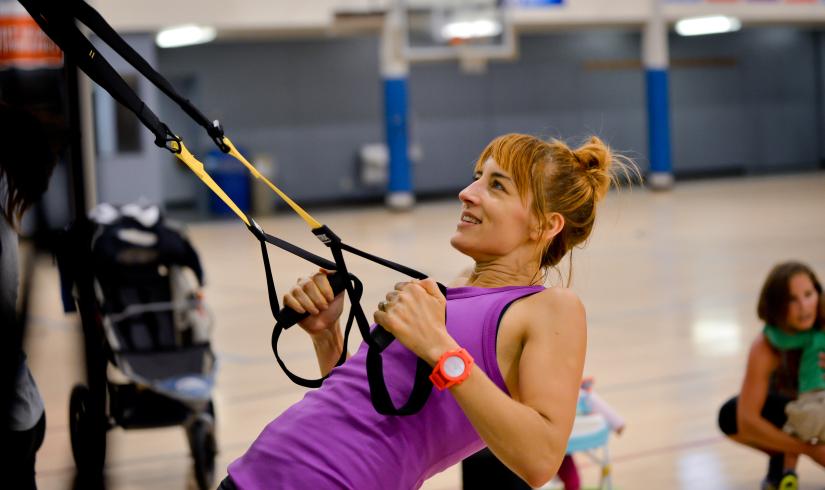 Eleanor tries low impact TRX in a purple tank top at the Morgan Family YMCA.
