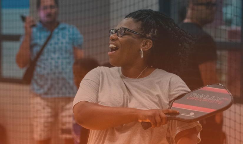 Pickleball player smiles with confidence after smashing a pickleball.