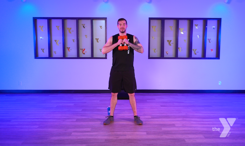 YMCA360 Instructor Bryce holds free weights and leads a newly released class.