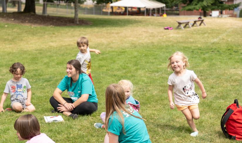 Campers playing duck duck goose at summer camp