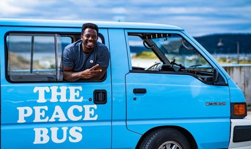 Kwabi throws up a peace sign from the window of his Peace Bus