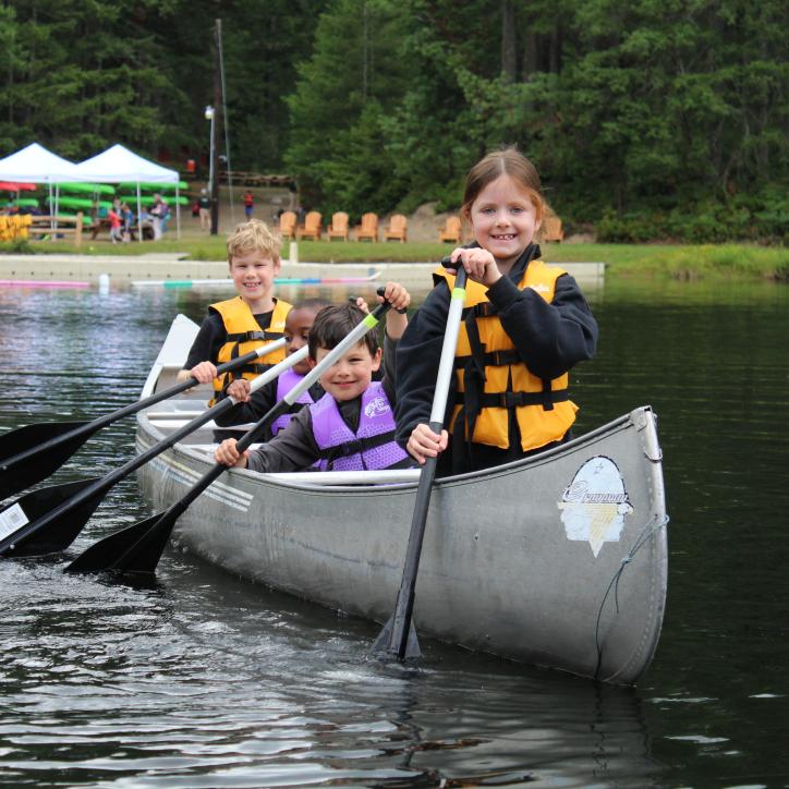 Four children canoeing at Camp Lake Helena