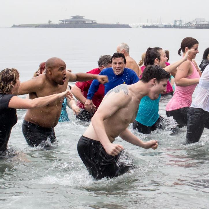 People run away from the cold Puget Sound at the Plunge event