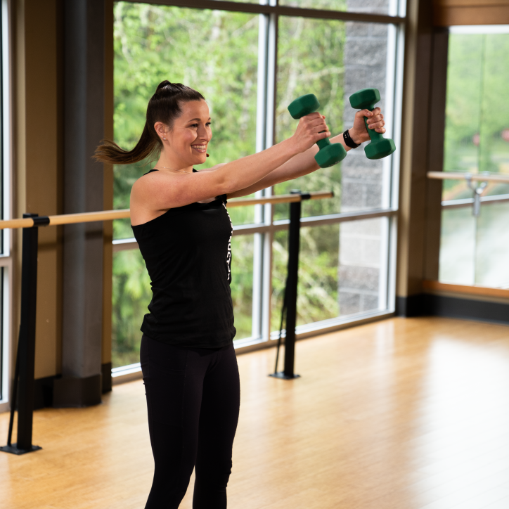 A young woman works out with weights in a fitness studio at YMCA of Pierce and Kitsap Counties.