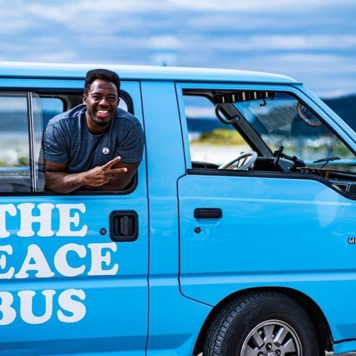 Kwabi throws up a peace sign from the window of his Peace Bus