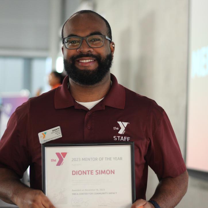 YMCA mentor of the year, Dionte Simon, smiling with his award.