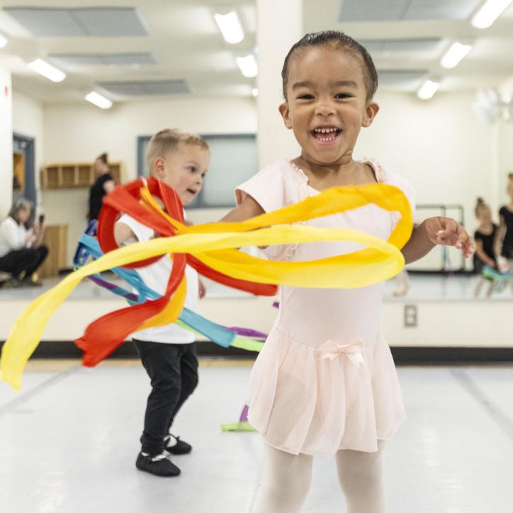 Toddler ballet students play with flow ribbons at the YMCA