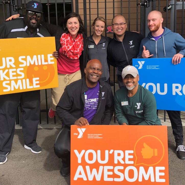 YMCA staff holding up thank you signs 