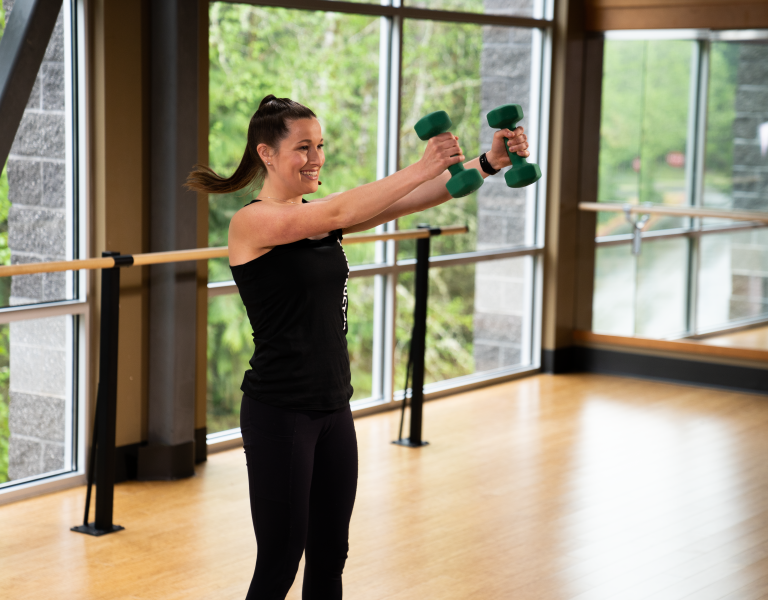 A young woman works out with weights in a fitness studio at YMCA of Pierce and Kitsap Counties.