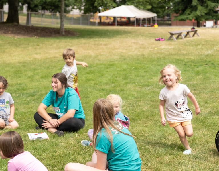 Campers playing duck duck goose at summer camp